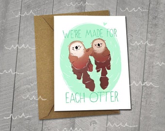 May include: A greeting card with an illustration of two otters holding onto each other. The card reads "We're made for each otter".