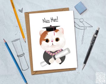 May include: A graduation greeting card featuring a cartoon cat wearing a graduation cap and gown, holding a diploma. The card reads "Nice Hat!" in black text. The cat is white and brown with large eyes. The card is on a brown envelope.