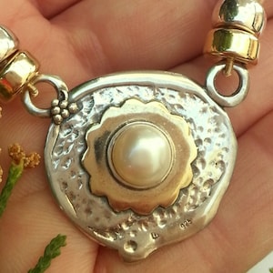 pink pearls necklace, silver pendant with a gold flower and a pearl