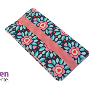 Könnte beinhalten: Eine rosa-blaue Blumen-Handyhülle mit einem rosa Gummiband. Die Hülle hat ein sich wiederholendes Muster aus rosa Blumen mit orangefarbenen Zentren und grünen Blättern auf dunkelblauem Hintergrund.