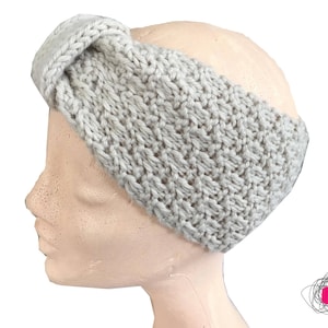 Peut inclure: Bandeau tricoté gris clair avec un motif texturé. Le bandeau est présenté sur une tête de mannequin, mettant en valeur son design et son ajustement. La matière tricotée semble douce et chaude, adaptée aux temps frais.