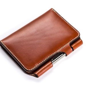 May include: A brown leather wallet with a pen holder and a stitched edge.
