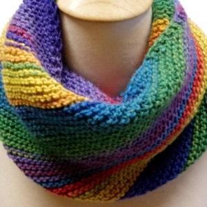 May include: A colorful knitted infinity scarf with stripes of purple, blue, green, yellow, orange, and red.
