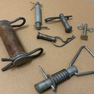 May include: Assortment of metal spring loaded and pin style clasps.  The clasps are in various shapes and sizes, including a triangular shape, a round shape, and a rectangular shape.  The clasps are made of metal and have a silver finish.