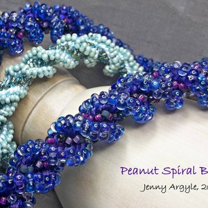 May include: Close-up of two beaded spiral braids. One is a deep blue, the other a light blue-green. The braids are made of small, round beads and are twisted around a central core. The text "Peanut Spiral Braid" and "Jenny Argyle, 2016" are visible.