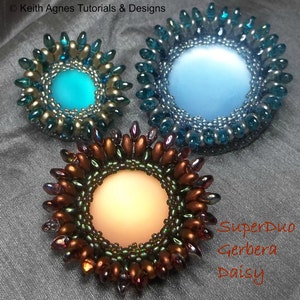 May include: Three beaded, circular designs with a central light-colored circle. The top two are teal and blue, while the bottom one is brown and green. The designs are labeled "SuperDuo Gerbera Daisy" and "Keith Agnes Tutorials & Designs".