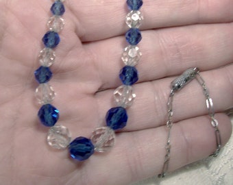 May include: A blue and clear crystal beaded necklace with a silver clasp.