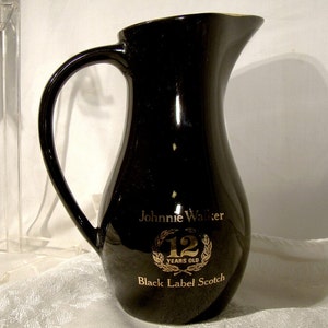 May include: Black ceramic pitcher with gold lettering that reads "Johnnie Walker 12 Years Old Black Label Scotch".