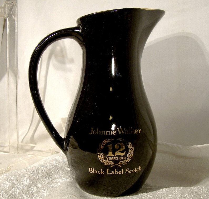 May include: Black ceramic pitcher with gold lettering that reads "Johnnie Walker 12 Years Old Black Label Scotch".