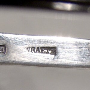 Puede incluir: Primer plano de un utensilio plateado con las marcas "925" y "WRAETZ" en la parte posterior.