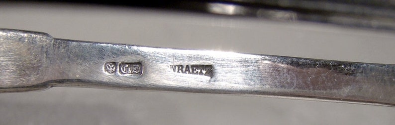 Puede incluir: Primer plano de un utensilio plateado con las marcas "925" y "WRAETZ" en la parte posterior.