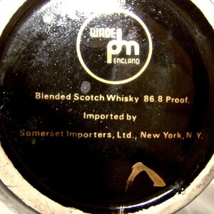 May include: Black and gold label on a bottle of blended Scotch whisky. The label reads "Wade pm England" and "Blended Scotch Whisky 86.8 Proof. Imported by Somerset Importers, Ltd., New York, N.Y."