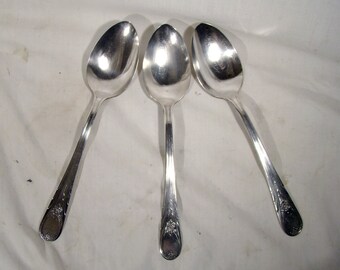 May include: Three silver spoons with ornate designs on the handles.