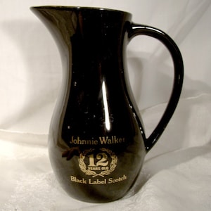 May include: Black ceramic pitcher with a gold Johnnie Walker Black Label Scotch 12 Years Old logo.
