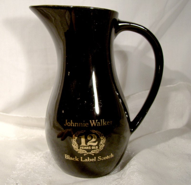 May include: Black ceramic pitcher with a gold Johnnie Walker Black Label Scotch 12 Years Old logo.