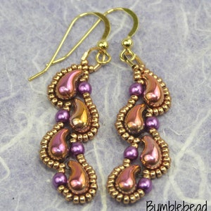 Può includere: Un paio di orecchini pendenti con un gancio dorato e un design di perline viola e rame a forma di goccia.