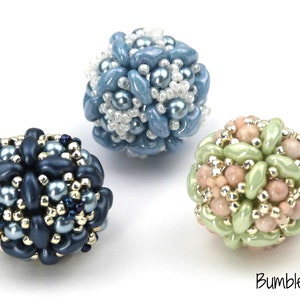 May include: Three beaded spheres in different colours. The first sphere is blue and white, the second is dark blue and gold, and the third is light green and pink.
