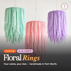 May include: Three hanging circular decorations featuring cascading fabric strips in mint green, soft pink, and lavender. Each ring is suspended by thin wires. Text on the image reads: CUSTOM A LA CARTE Floral Rings Your colors, your size — handmade in Fort Worth.