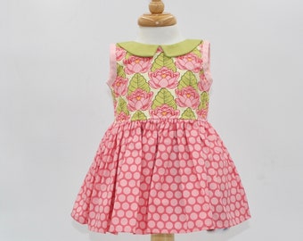 Size 12-18 months. Pink flowers pair so sweetly with a green collar on this sleeveless dress for a little girl. Ready to ship!