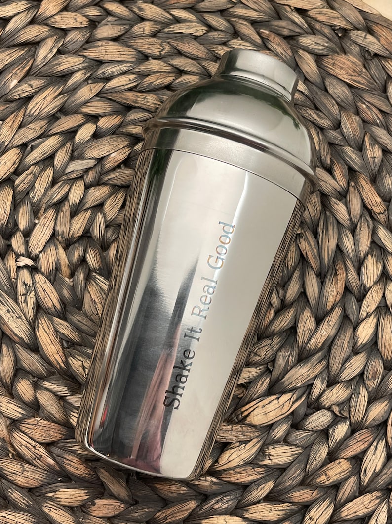 May include: A silver cocktail shaker with the text "Shake It Real Good" engraved on the side.