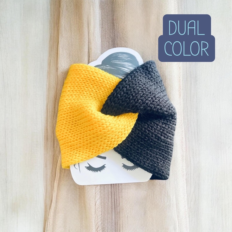 May include: A dual-colour knitted headband featuring a twisted design with one half in bright yellow and the other half in dark charcoal grey. The headband is displayed on a white card with a graphic of closed eyes and the text DUAL COLOR.