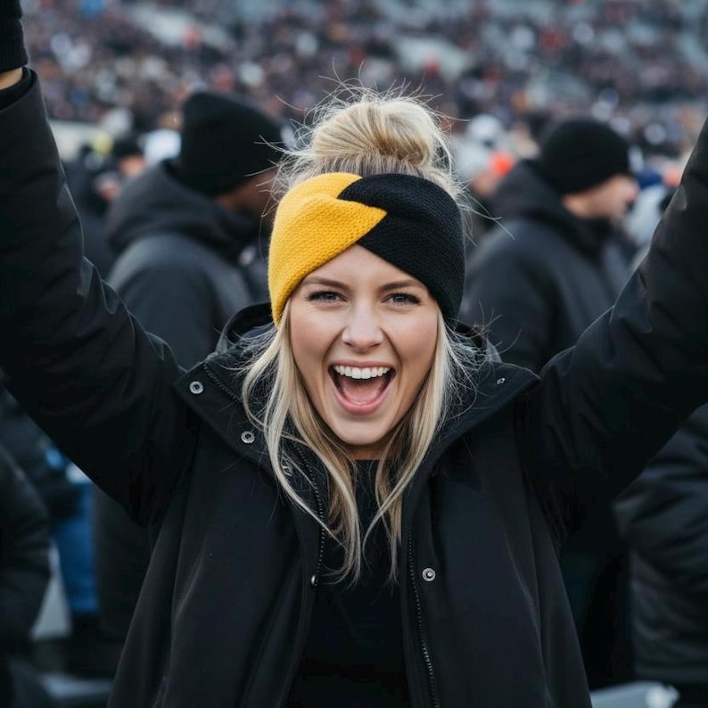 May include: A knitted headband featuring a colour-blocked design with one half in bright yellow and the other half in solid black. The accessory has a twisted knot detail at the centre front and is worn over blonde hair, paired with a black winter jacket.