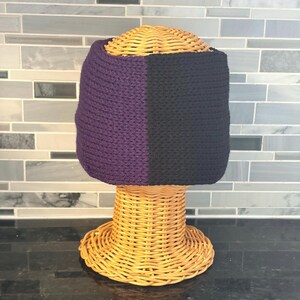 Black and purple knit twist headband on wicker model