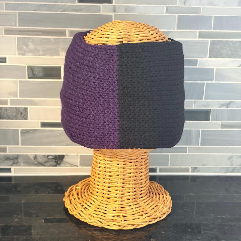 Black and purple knit twist headband on wicker model