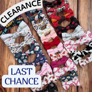May include: A collection of fabric bow ties in various patterns and colors, including pink, red, and blue. Some bows feature text, and the image includes the words "CLEARANCE" and "LAST CHANCE."