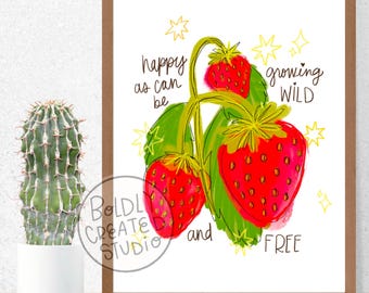 May include: A framed art print with a strawberry illustration. The image shows vibrant red strawberries, green leaves, and the words "happy as can be growing wild and free" in black script. The frame is a warm brown colour.