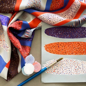 May include: A blue, red and white patterned silk scarf with a paintbrush and three small containers of paint. The paint colours are white, red and blue.