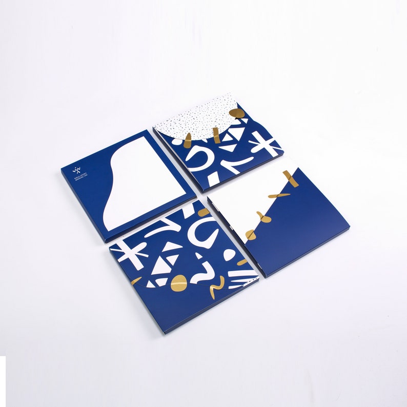 May include: Four blue square cards with white and gold abstract designs. The cards are arranged in a grid pattern.