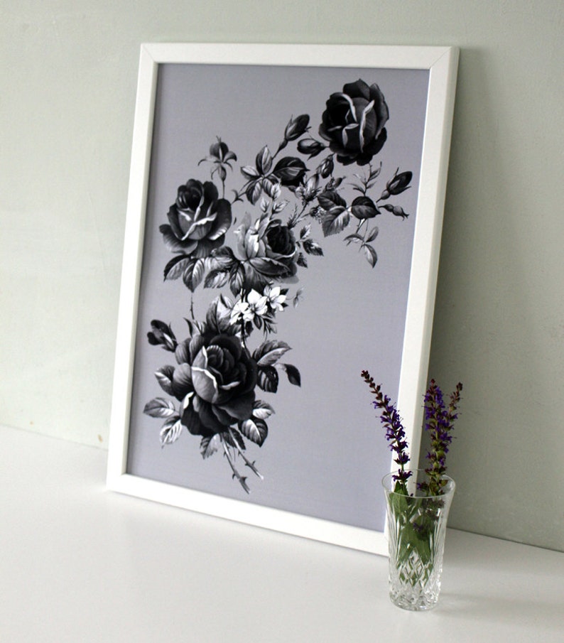 May include: A black and white framed print of a floral arrangement featuring black roses and white flowers on a light gray background.