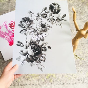 May include: A black and white print of a bouquet of roses with leaves and stems. The roses are in various stages of bloom, with some fully open and others still in bud.