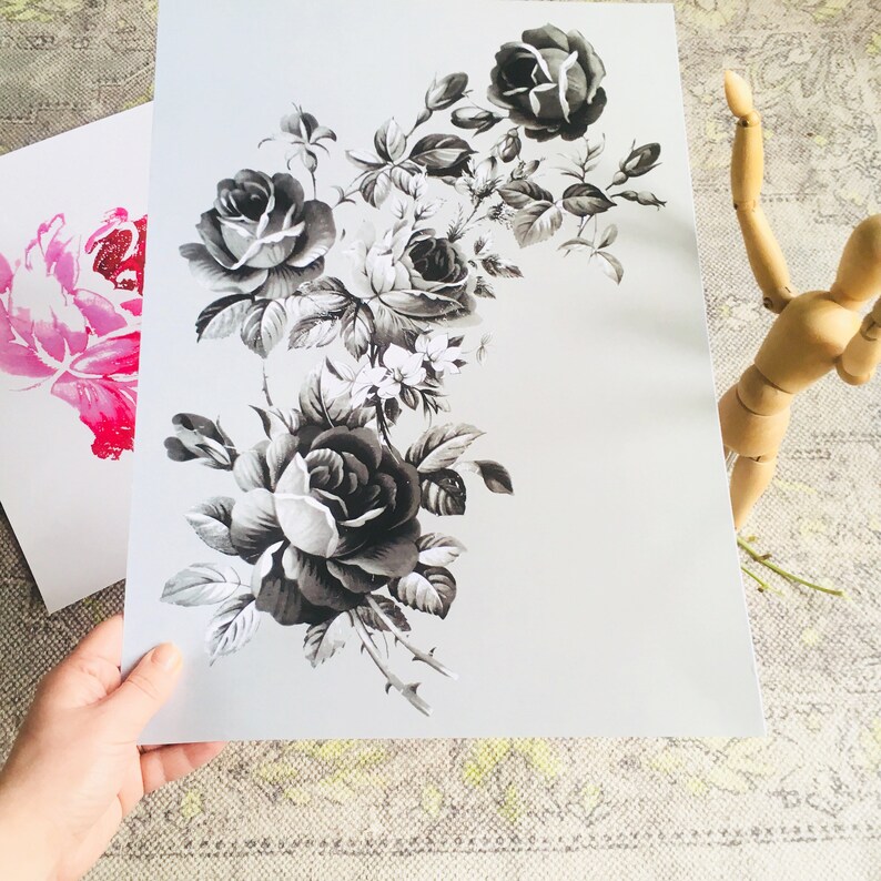 May include: A black and white print of a bouquet of roses with leaves and stems. The roses are in various stages of bloom, with some fully open and others still in bud.