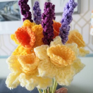 May include: A bouquet of crocheted flowers, including yellow daffodils and purple lavender.