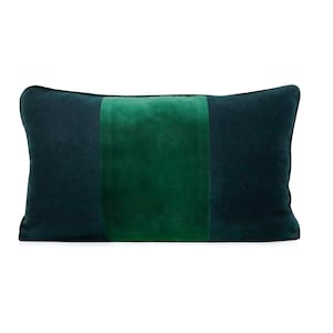 May include: A rectangular decorative pillow with a dark teal exterior and a central vertical stripe of emerald green. The pillow has a soft, velvety texture, and the color contrast creates a modern aesthetic.