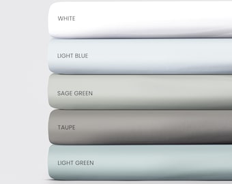 May include: Five fabric swatches stacked on top of each other. The swatches are white, light blue, sage green, taupe, and light green.