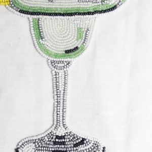 Choose this unique piece of wall decor and impress your guests with its artistic flair. Beaded margarita drink made of grey, silver, black, green and white beads. Sure, there are yellow ones to add the hint of lime in the drink.