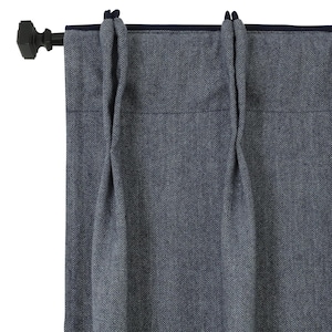 Puede incluir: Cortinas azul marino con estampado de espiga, con una barra y un terminal oscuros. Las cortinas tienen un borde azul oscuro y están parcialmente corridas, mostrando la textura y el diseño de la tela. La barra es marrón oscuro.