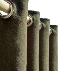 Puede incluir: Primer plano de cuatro cortinas de tela verde oscuro con ojales plateados y una barra de cortina de madera.