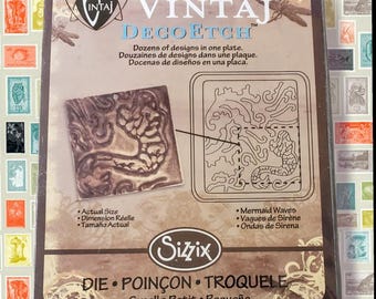 May include: A Vintaj Deco Etch die plate by Sizzix, featuring a mermaid waves design. The packaging includes the text "Dozens of designs in one plate" in English, French, and Spanish. The die is small.