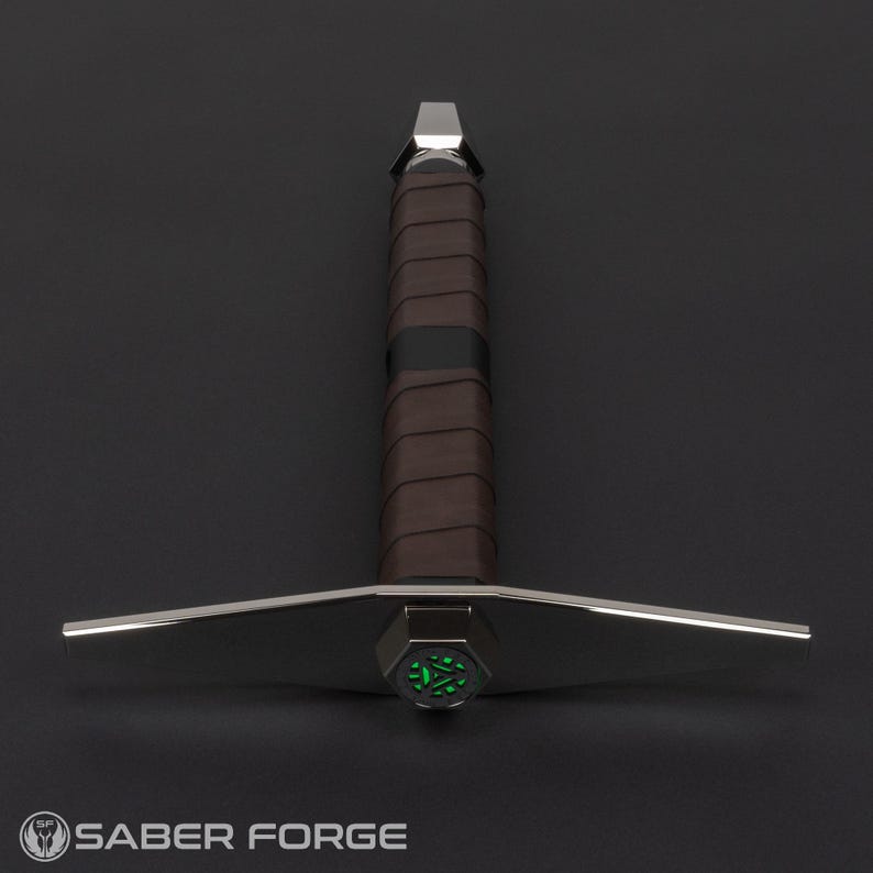 Op de afbeelding: Een zilveren lightsaber met een bruine leren greep en een groene gloeiende punt.