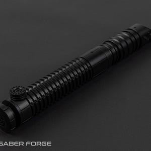May include: A black lightsaber hilt with a ribbed design and various circular and cylindrical components. The hilt has a textured grip and a pommel with a circular design. The Saber Forge logo is visible at the bottom.