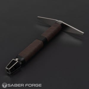 Op de afbeelding: Een zilveren en zwarte lightsaber met een bruine leren greep. De lightsaber heeft een plat, rechthoekig blad.