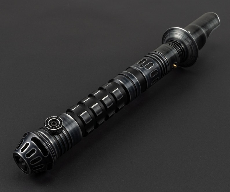 K&ouml;nnte beinhalten: Ein schwarzes Lichtschwert mit einem silbernen Griff und einem strukturierten Griff. Das Lichtschwert hat eine schwarze Klinge und eine silberne Spitze.