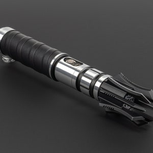 May include: A black and silver lightsaber with a detailed, intricate, and sharp-edged hilt.