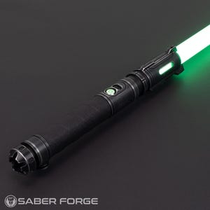 Pode incluir: Um sabre de luz preto com uma empunhadura texturizada e uma l&acirc;mina verde brilhante. O punho apresenta detalhes prateados e um bot&atilde;o de ativa&ccedil;&atilde;o verde. O logotipo Saber Forge &eacute; vis&iacute;vel.