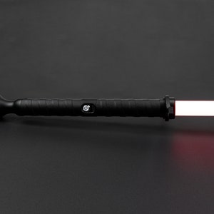 May include: A black lightsaber with a red blade. The lightsaber has a textured handle and a button on the side.
