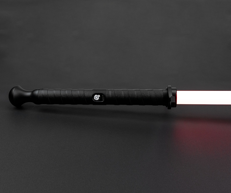May include: A black lightsaber with a red blade. The lightsaber has a textured handle and a button on the side.
